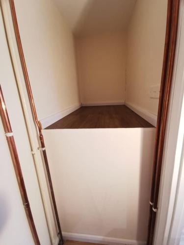 比斯特Private room in a lovely home的空衣柜,有白色的门和木地板