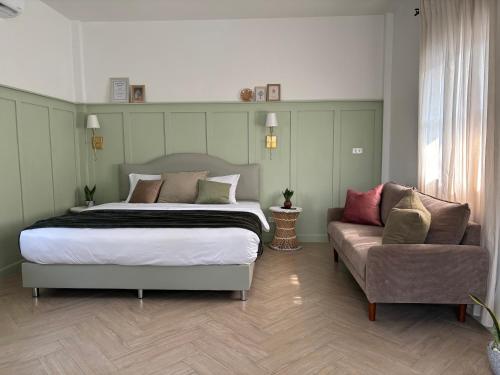 北碧Vawa Guesthouse的一间卧室配有一张大床和一张沙发