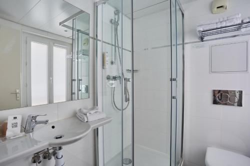 巴黎堡格林内尔埃菲尔铁塔酒店的一间带玻璃淋浴和水槽的浴室