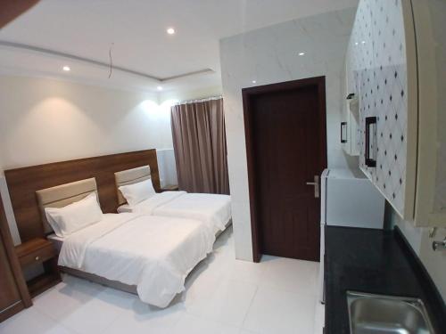 Quwayzahكيان التيسير للشقق المخدومة - Kayan Al Tayseer Serviced Apartments的酒店客房设有床和水槽