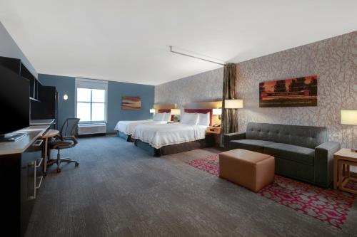 塔斯卡卢萨Home2 Suites by Hilton Tuscaloosa Downtown University Boulevard的酒店客房,配有床和沙发