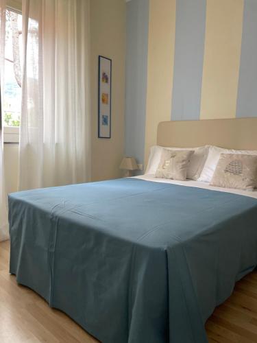阿拉西奥Locanda Kon Tiki的卧室里一张带蓝色毯子的床