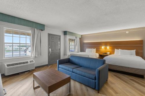 凤凰城La Quinta Inn by Wyndham Phoenix Thomas Road的酒店客房,设有两张床和一张蓝色的沙发