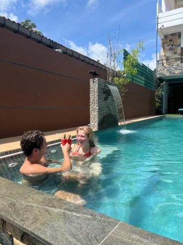 尼甘布Mama’s Boutique Beach Hotel的男孩和女孩在游泳池玩耍