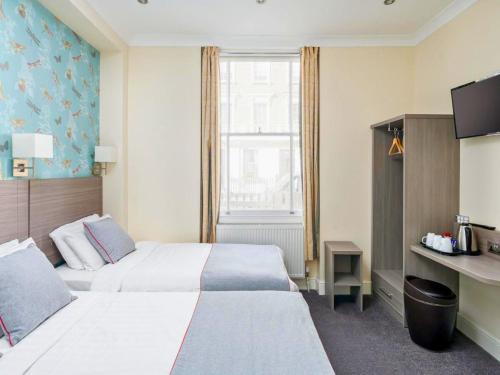 新德里stay in的酒店客房设有两张床和窗户。