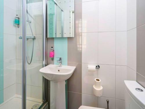 新德里stay in的白色的浴室设有水槽和淋浴。