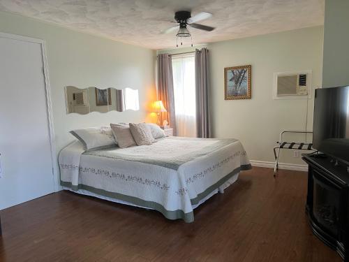 彼得伯勒Liftlock Guest House的一间白色卧室,配有床和电视