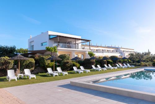 塔维拉Hotel Rural Quinta do Marco - Nature & Dining的一个带游泳池和椅子的度假胜地和一座建筑