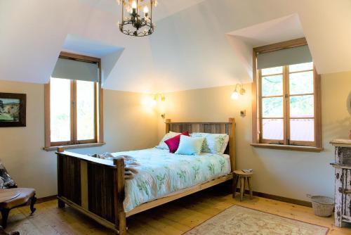 克拉佛斯Adelaide Hills Camellia Cottage Wifi的一间卧室设有一张床和两个窗户。