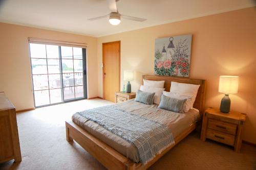 Encounter Bay海湾之遇家庭度假屋的一间卧室设有一张床和一个大窗户