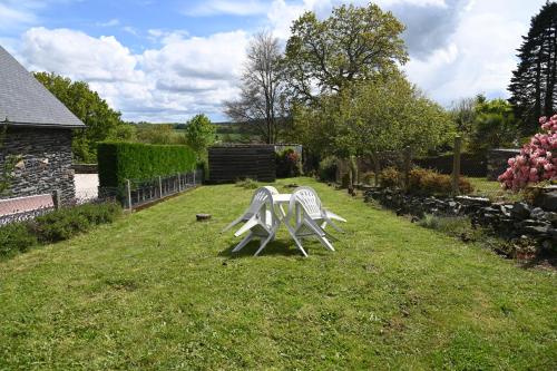 CaurelCaurel Cottage的两把白色椅子坐在院子里的草地上
