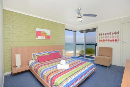 埃利奥特港南海海滨公寓 的一间卧室配有一张大床和一把椅子