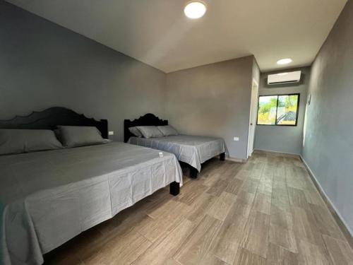 JucuaránRancho Agua Fria的一间卧室设有两张床,铺有木地板