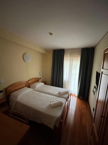 加尔达Hotel Giotto的酒店客房设有两张床和窗户。