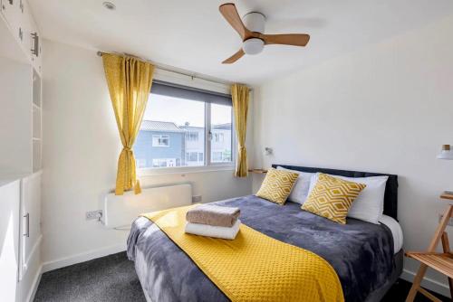 彭布罗克郡Beach Woods Coastal Path chalet的一间卧室配有一张带黄色毯子和窗户的床