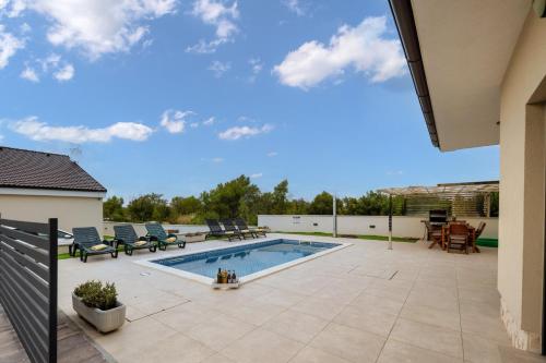 比利切Villa Shaula 2的庭院内的游泳池,配有椅子和庭院