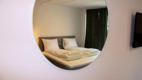 措斯楚斯A Hotels Apartments Høje Taastrup的镜子反射着房间里的床