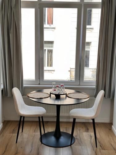 布鲁塞尔Cozy South-Up的窗户间配有一张桌子和两把椅子