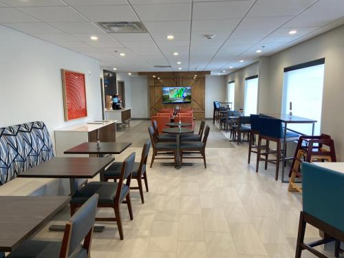 伊利里亚Holiday Inn Express & Suites Elyria, an IHG Hotel的一间带桌椅和电视的用餐室