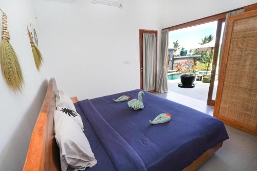 乌布Villa Sawah Ramah的一间卧室配有一张带蓝色床单和毛巾的床。