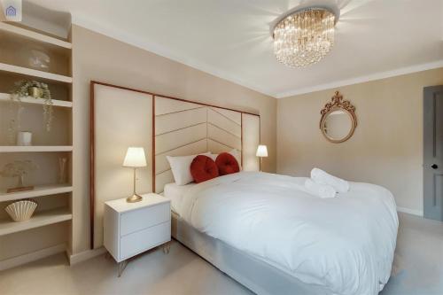 伦敦The Shepherd Residence的卧室配有一张白色大床和吊灯。