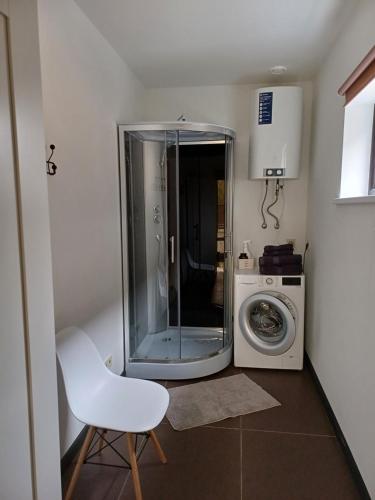 马鲁佩Lambertu ielas rezidence的一间带洗衣机和白色椅子的浴室