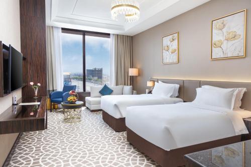 海米斯穆谢特Nivel Hotel的酒店客房设有两张床和电视。