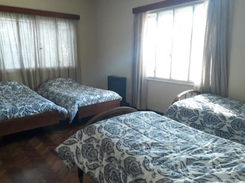 瓜伊马延Mendoza - Casa Cardozo的带窗户的客房内设有三张床。