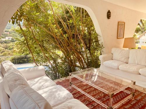 滨海卡瓦莱尔Villa Hirondelles 35的客厅配有白色沙发和玻璃桌