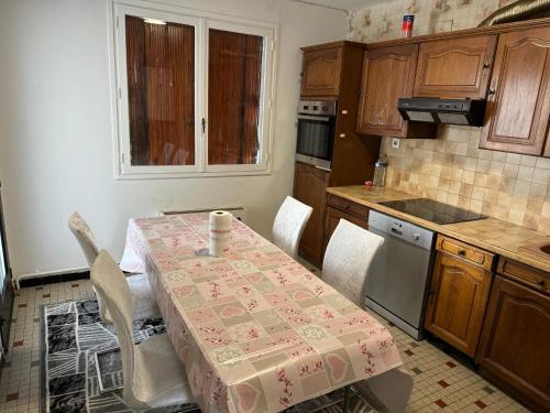 克莱蒙费朗Maison 3 Chambres的厨房配有桌子和桌布