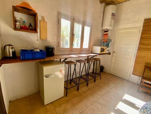 蒂诺加斯塔El Corti Tinogasta的厨房配有冰箱和一些酒吧凳