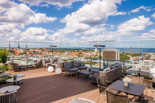 塔林丽笙布鲁酒店天空酒店的屋顶甲板配有桌椅,享有城市美景