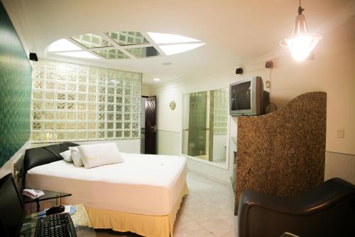 帕纳米林Vert Motel Parnamirim的一间酒店客房,配有一张床和一台电视