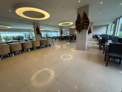 萨姆松Ayvacık Hotel Restaurant的餐厅内带桌椅的用餐室