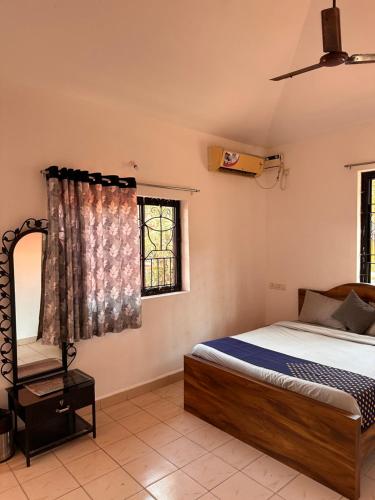 Goasun and sea guest house calangute的一间卧室设有一张床和一个窗口