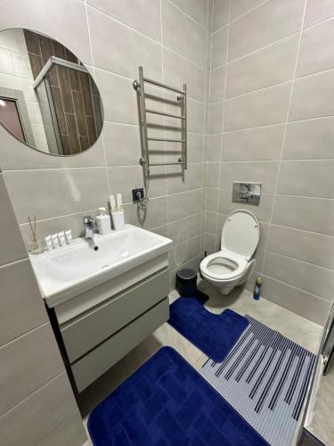 阿拉木图Студия в теплых тонах, Эксклюзив的浴室设有水槽和蓝色地毯的卫生间。
