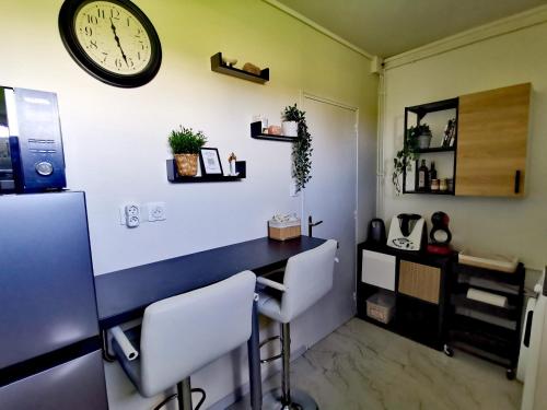 塞讷塞迪容L'atelier de Jane的一间设有书桌和墙上的时钟的房间