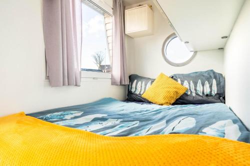 兹瓦茨勒伊斯Charming and cozy Houseboat near Giethoorn的一个小房间的一个床位,设有窗户