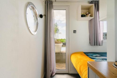 兹瓦茨勒伊斯Charming and cozy Houseboat near Giethoorn的卧室设有通往阳台的门