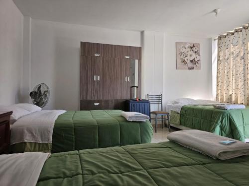 伊察Hospedaje Las Parraz的一间卧室配有两张带绿床单的床