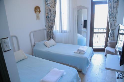 阿拉恰特Apaz Alaçatı Hotel的酒店客房设有两张床和一个阳台。
