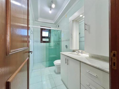 南卡希亚斯Quarto em Apartamento Amplo e Confortável的一间带卫生间和玻璃淋浴间的浴室