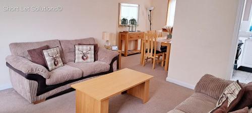 塞顿港Curlew - Port Seton的客厅配有沙发和桌子