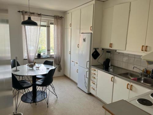 马尔默Johnericssonsväg Apartment Malmö的厨房配有桌椅和冰箱。