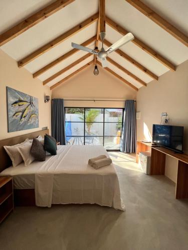 图杜Manta Stay Thoddoo, Maldives的一间卧室配有一张大床和吊扇