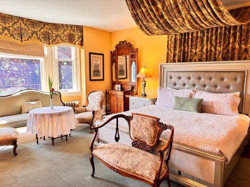 维多利亚前城堡旅馆的一间卧室配有一张床、一张沙发和一张桌子