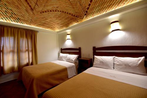 乔卢拉Hotel Santa Irene的酒店客房设有两张床和天花板
