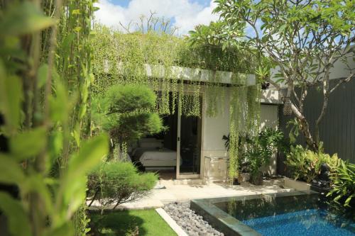 金巴兰Vlad Bali Villa的一个带游泳池和树木的花园