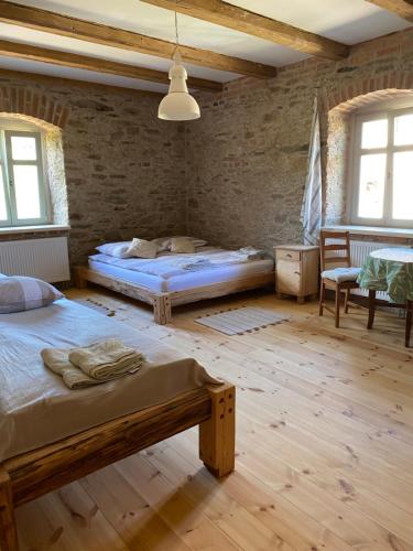 莱希纳DOM PIWOWARA的砖墙内一间卧室,配有两张床