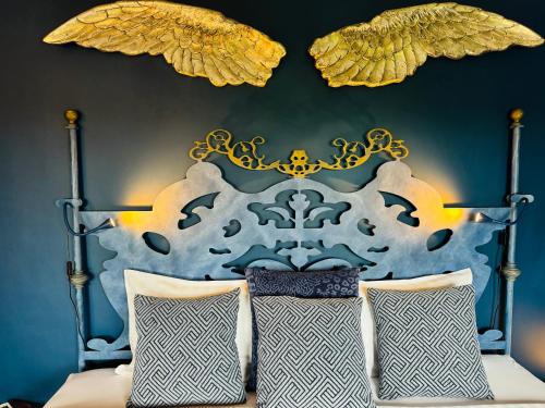 卢斯Palm View Guesthouse, adults only的一间卧室配有一张带蓝色和金色床头板的床